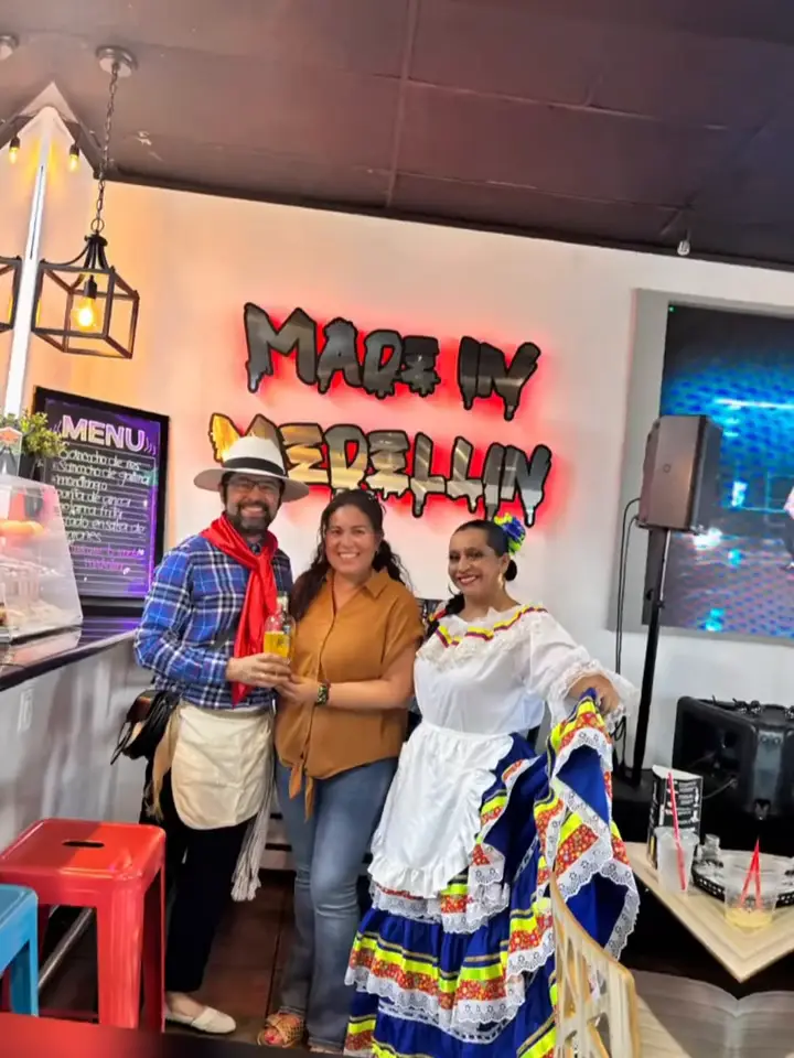 Bailarines de ColombiArte en traje típico posando con una invitada en Made in Medellín